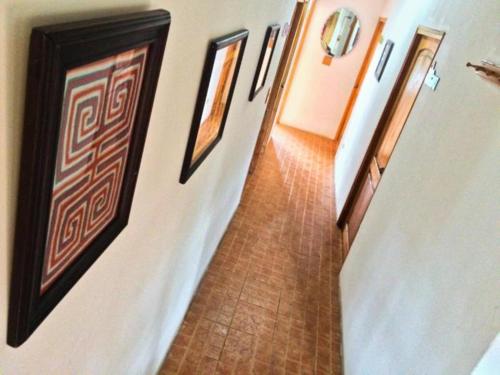 an empty hallway with pictures on the walls of a building at Spanish by the River - Boquete in Boquete