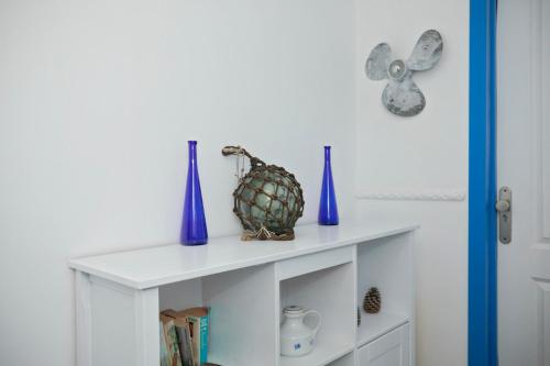 a white cabinet with blue vases on top of it at Hostel Neon Tenerife in Guaza