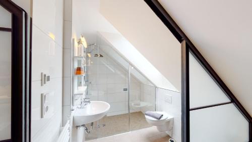 a white bathroom with a sink and a toilet at Schönhagener Mühle in Pritzwalk