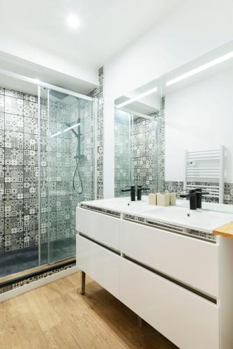 une salle de bain avec une douche en verre et un lavabo dans l'établissement Le carré de Nicolas, à Nancy