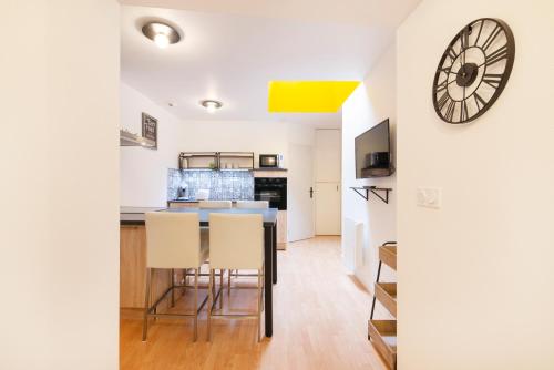 une cuisine et une salle à manger avec une horloge murale dans l'établissement Le carré de Nicolas, à Nancy