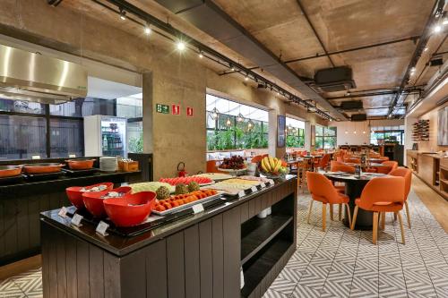 a restaurant with a buffet line with fruits and vegetables at Transamerica Executive Jardins in Sao Paulo