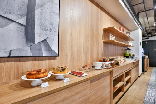a bakery with several different types of bread on a counter at Transamerica Executive Jardins in Sao Paulo