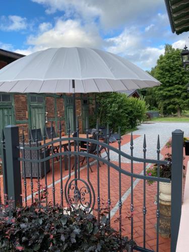 a large white umbrella on a iron fence at Villa B das zauberhafte Chalet in Vetschau