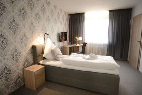 a hotel room with a bed and a window at Landhotel Kussmann in Wrexen