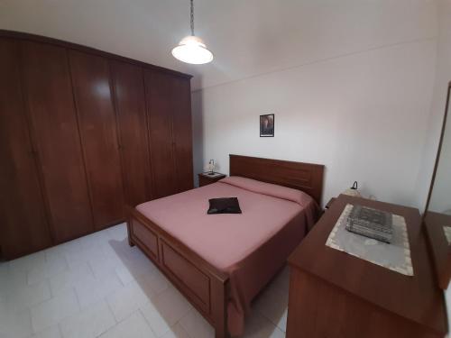 a small bedroom with a bed and a desk at Appartamenti Vacanza al centro in Pantelleria