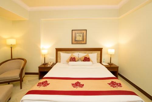 a hotel room with a bed and a chair at Clarion Bella Casa at Airport in Jaipur