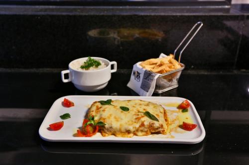 a table with a plate of food and a drink at Transamerica Executive Jardins in Sao Paulo