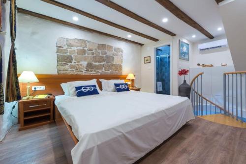 a bedroom with a large bed and a stone wall at New Apartment La Barca Old Town in Dubrovnik