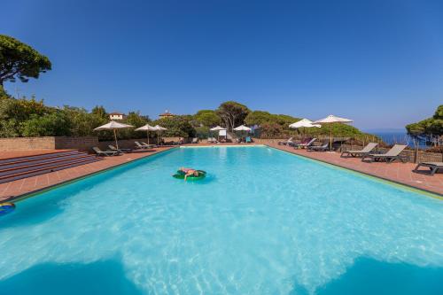 a person laying on a raft in a swimming pool at Tenuta Delle Ripalte in Capoliveri