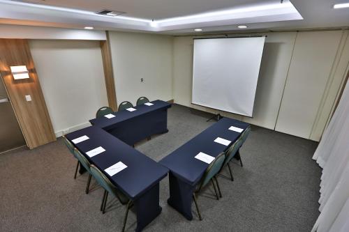 a conference room with blue tables and chairs and a whiteboard at Transamerica Executive Jardins in Sao Paulo