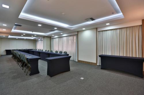a conference room with a row of tables and chairs at Transamerica Executive Jardins in Sao Paulo