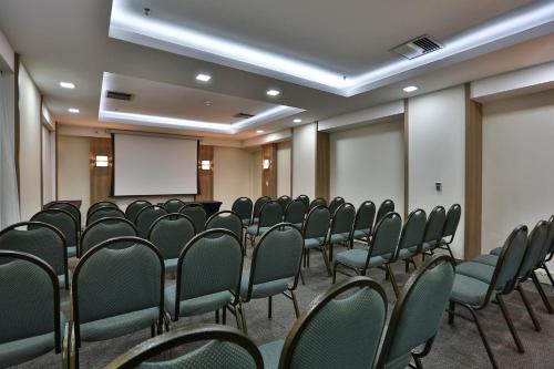 a conference room with green chairs and a whiteboard at Transamerica Executive Jardins in Sao Paulo