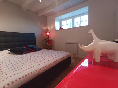 a bedroom with a bed with a toy horse on a table at Gîte de charme dans ancienne seigneurie in Le Pin-Saint-Denis
