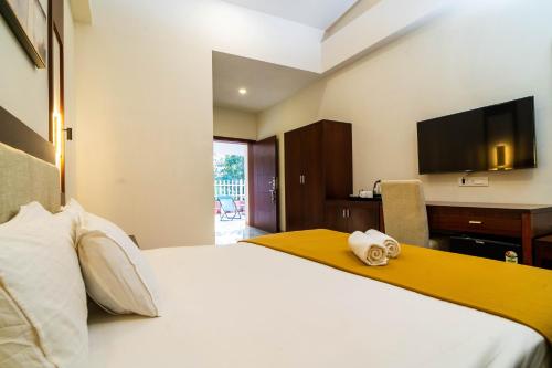 a hotel room with a bed and a television at Grande Alpine Hotel in Vagator