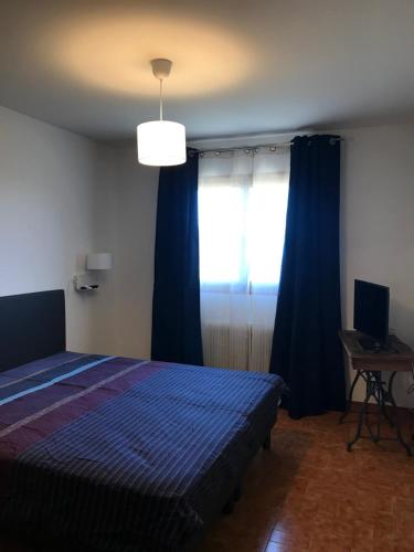 une chambre avec un lit et une fenêtre avec des rideaux bleus dans l'établissement VILLA EVE, à Chateauneuf Villevieille