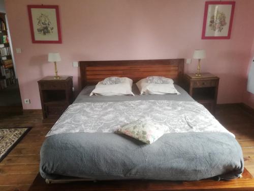 a bedroom with a large bed with two pillows at Hôtellerie Jardiniers Gourmands in Morsains