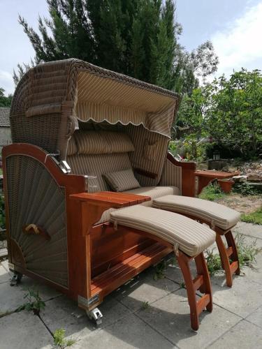 a wicker chair and bench sitting on a patio at Hôtellerie Jardiniers Gourmands in Morsains