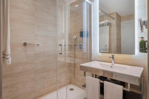 a bathroom with a sink and a shower at Melia Alicante in Alicante