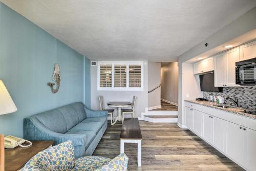 a living room with a blue couch and a kitchen at Oceanfront Condo with Views in North Myrtle Beach! in Myrtle Beach