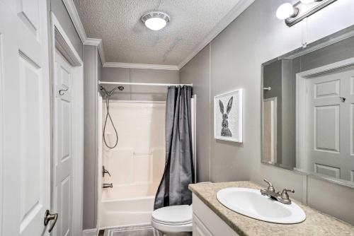 a bathroom with a sink and a toilet and a mirror at Cypress Point Spacious Home Pier and Boat Launch! in Alliance