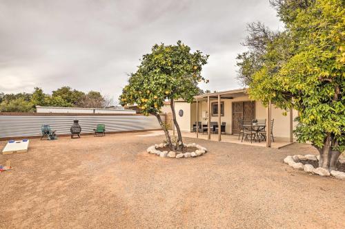 a house with a tree in the middle of a yard at Sunny Tucson Abode with Fire Pit 9 Mi to U of A in Tucson