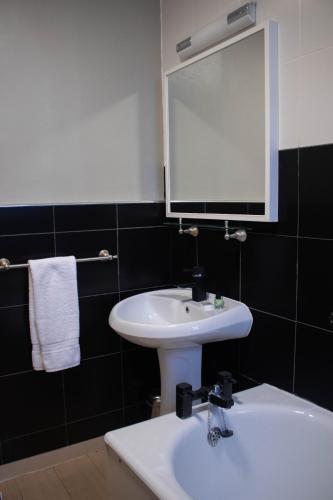 a bathroom with a white sink and a mirror at The Rosedale Hotel & Restaurant in Portree