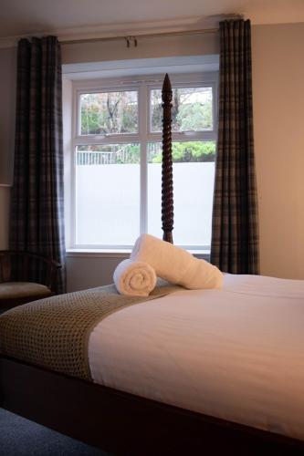 a bed in a room with a window and a bedvisor at The Rosedale Hotel & Restaurant in Portree