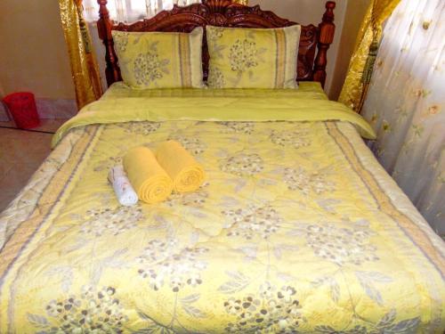 Una cama con sábanas amarillas y toallas amarillas. en Pangulatan Beach Resort en El Nido