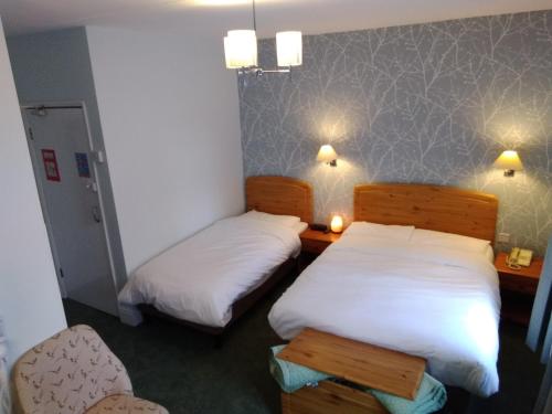 a hotel room with two beds and two lamps at River Hotel in Oxford