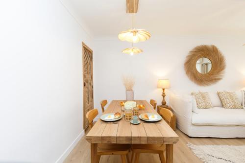 - un salon avec une table en bois et un canapé blanc dans l'établissement Hippie Palm Beach YourHostHelper, à Cannes