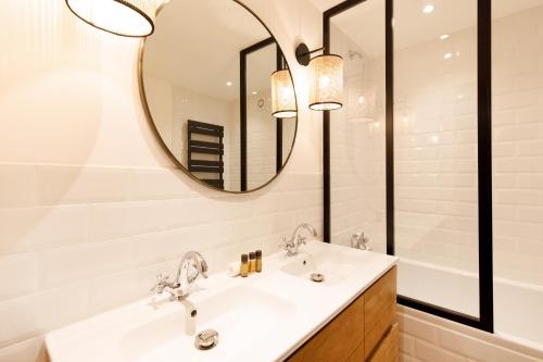 une salle de bain avec un lavabo et un miroir dans l'établissement Hippie Palm Beach YourHostHelper, à Cannes