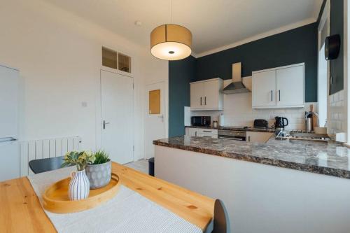 eine Küche mit einem Holztisch und einer Theke in der Unterkunft The Trossachs Apartment in Stirling