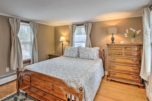 a bedroom with a bed and a dresser and windows at Kennebunk Home with Yard Less Than 1 Mile to Dock Square! in Kennebunk