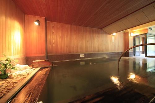 a swimming pool in a house with a pool at Ryotei Hanayura in Noboribetsu