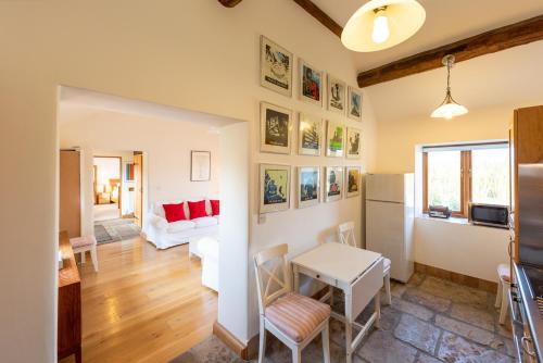 a kitchen and living room with a table and a refrigerator at Whitley Coach House in Whitley