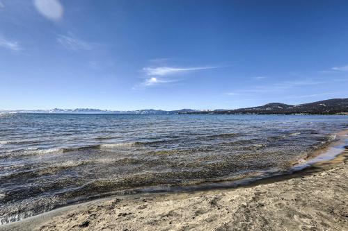 a beach with the ocean and mountains in the background at Dog-Friendly Kings Beach Log Cabin with Hot Tub! in Kings Beach