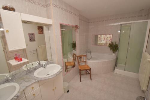 y baño con 2 lavabos, bañera y bañera. en Autrefois La Modiste, en Saint-Clar