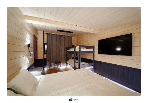 1 dormitorio con 1 cama y TV en una habitación en Posterunek Wiżajny en Wiżajny