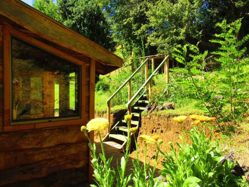 a wooden stairway leading to a cabin in a garden at Refugio Montaña Kultrun Mawida, Mini-Cabaña con baño y cocina privada in Curacautín