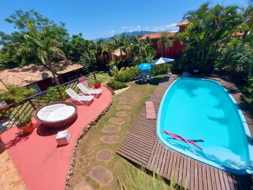 a backyard with a swimming pool and some chairs at Pousada VistaCalma in Praia do Rosa