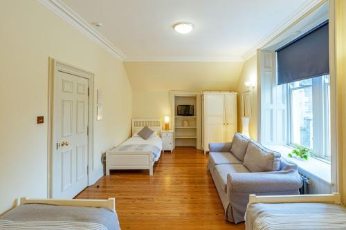 a living room with a couch and a bed and window at Stewart Apartment in Newton Stewart