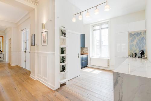 Cette chambre blanche est dotée de murs blancs et de parquet. dans l'établissement Le Palais de Saint-Jean, à Nancy