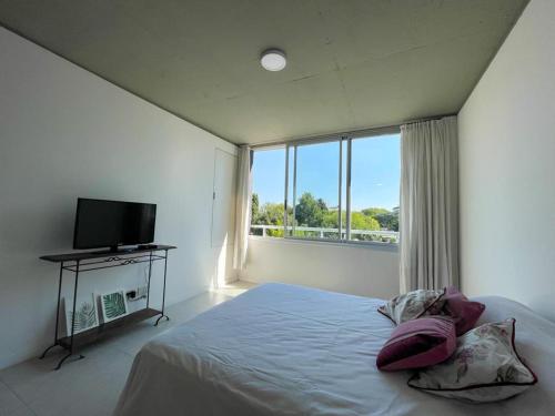 een slaapkamer met een bed en een groot raam bij Monoambiente Drumond in Adrogué