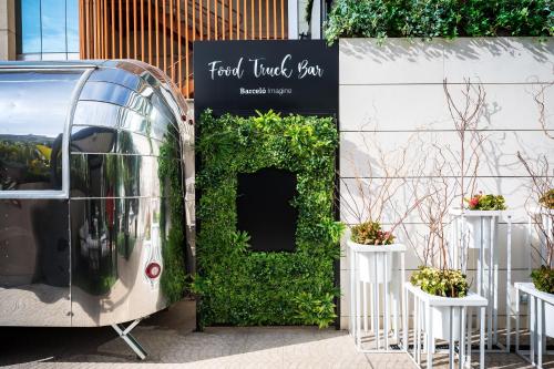 a bus parked in front of a sign with plants at Barceló Imagine in Madrid