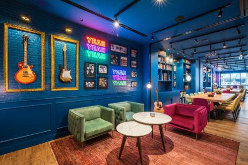 a restaurant with tables and chairs and guitars on the wall at Barceló Imagine in Madrid