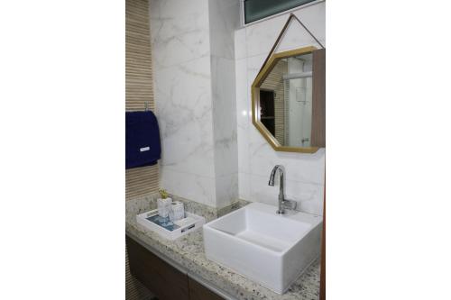 a bathroom with a white sink and a mirror at Makambira Residence no Centro de Porto de Galinhas in Porto De Galinhas