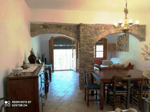 a kitchen and dining room with a stone wall at casa sobre rio Noguera Pallaresa in Gerri