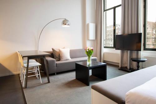 a living room with a couch and a table at Hapimag Apartments Amsterdam in Amsterdam