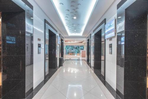 a hallway of a building with black and white tiles at RedLiving Apartemen Grand Kamala Lagoon - Pekayon Tower Barclay North in Pekayon Satu